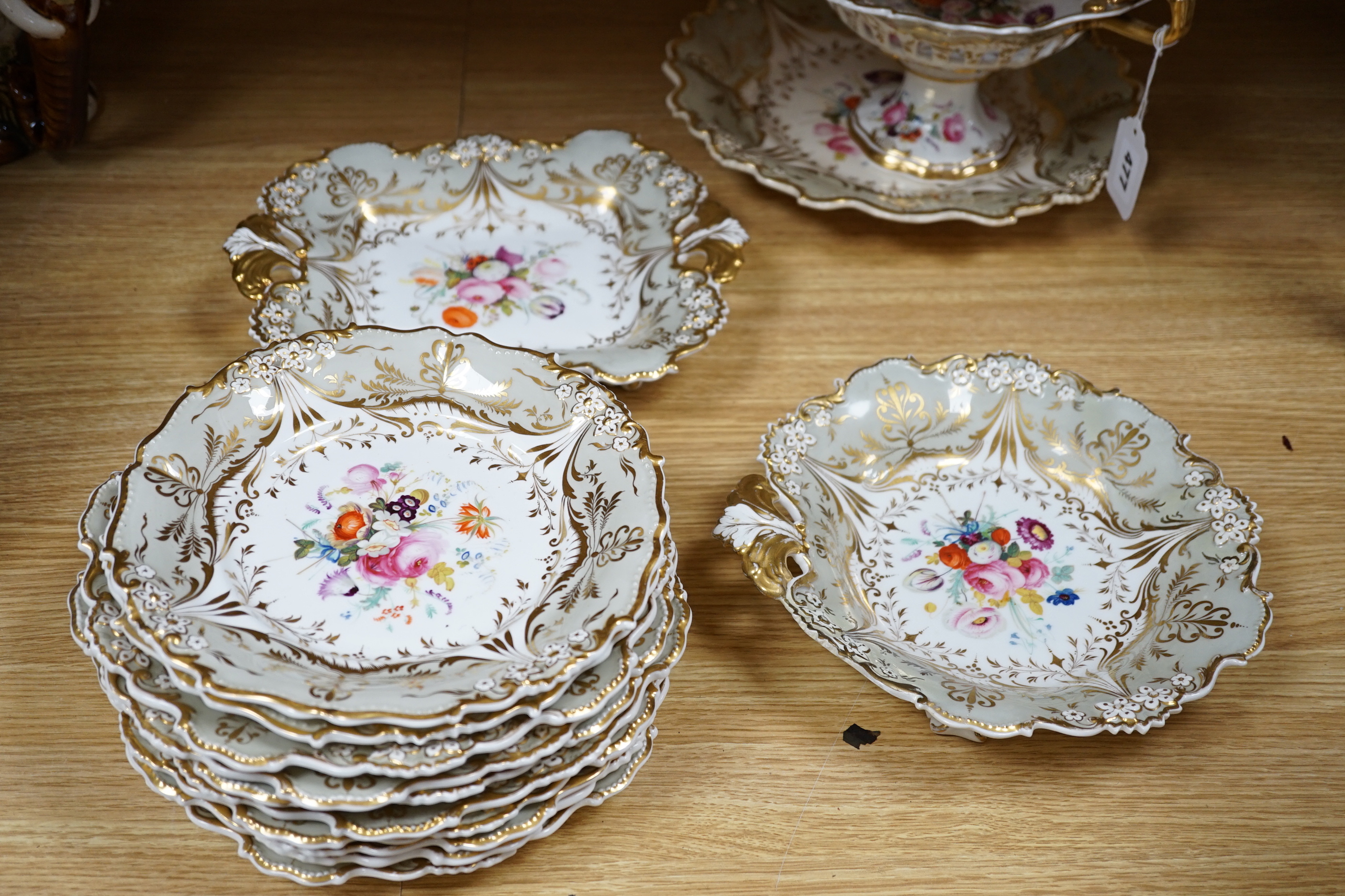 A Davenport porcelain part dessert service, each piece painted with a differing floral bouquet, within shaped grey and gilt borders